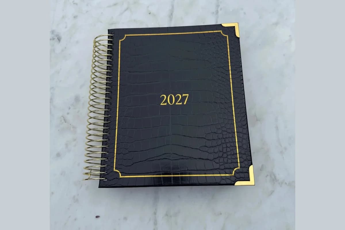 2027 Lynx Point Planner with a black croc-texture cover, gold corners and gold coil on grey marble