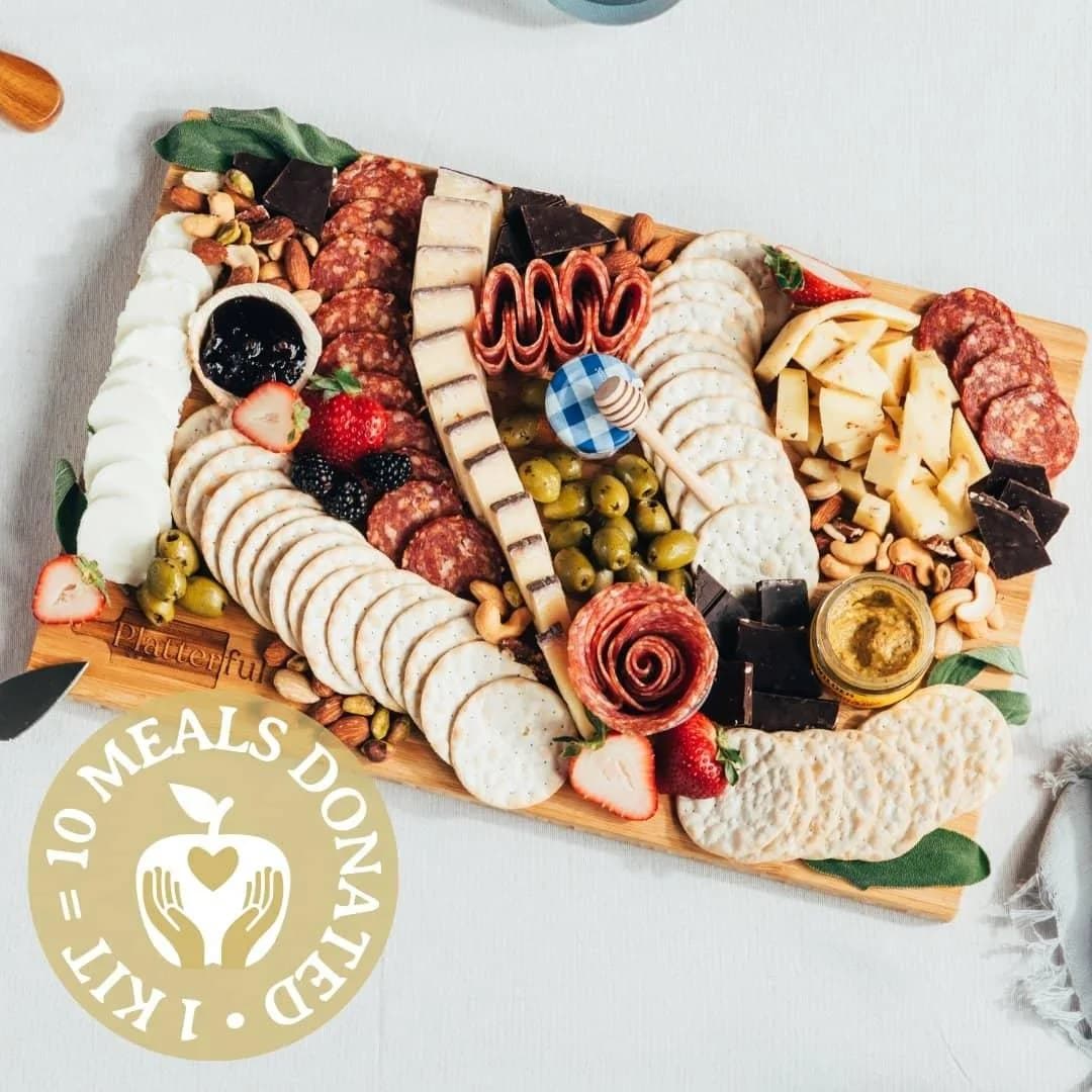 Finished charcuterie board built from a Platterful kit, with cheeses, cured meats, crackers, fruit and olives
